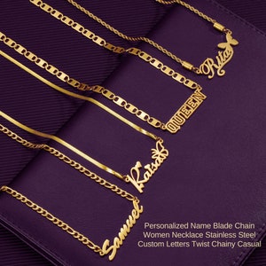 以下が含まれることがあります： 異なるチェーンスタイルとパーソナライズされた名前のペンダントが付いた、5本のゴールドネックレス。名前はサミュエル、キャット、クイーン、リタ。リタのペンダントには蝶のチャームが付いています。