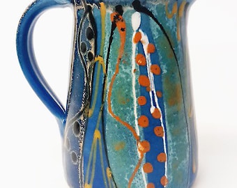 Unique handmade stoneware jug. Deep midnight blue satin glaze exterior, fresh glossy turquoise inside for easy cleaning. Aprox 15 cm tall.