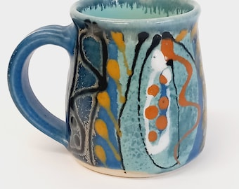 Handmade stoneware ceramic espresso cup, perfect small mug for coffee. Deep blue mug with colourful decoration.