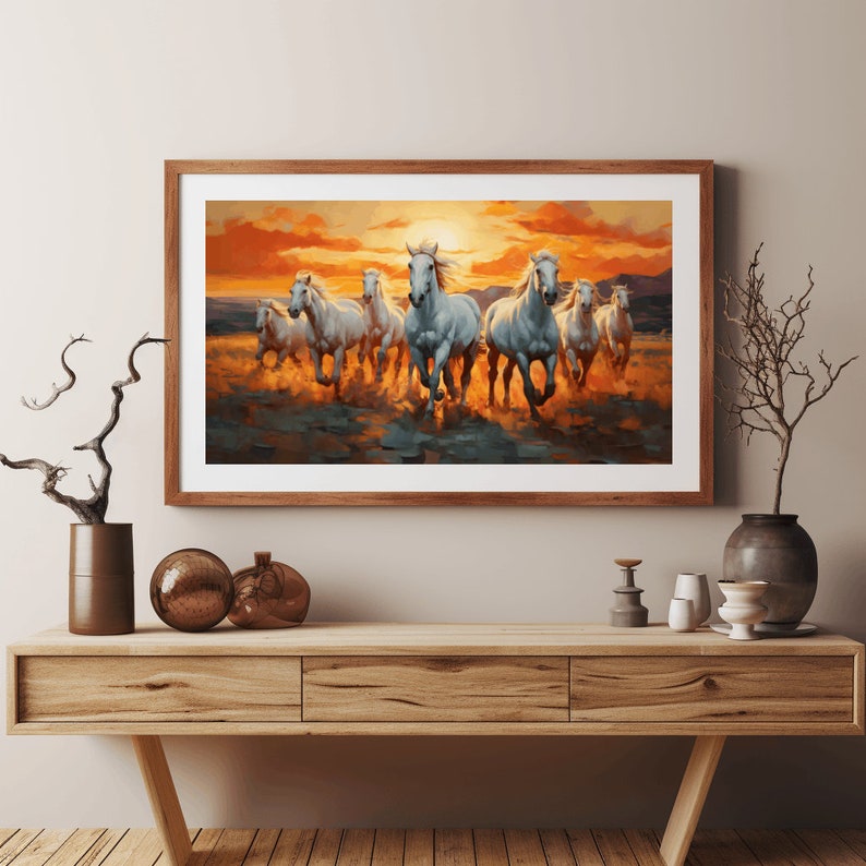 May include: A framed painting of a herd of white horses running through a field at sunset. The horses are in a line, with the lead horse facing the viewer. The sky is a vibrant orange and yellow, and the field is a soft green.