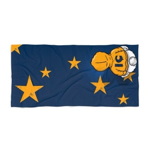 May include: A blue beach towel with a cartoon character wearing a yellow jacket and a white hat. The towel has yellow stars on it.