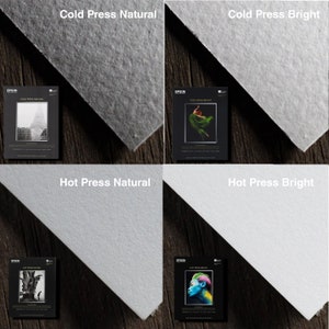 May include: Four samples of Epson Cold Press and Hot Press paper, each with a different image printed on it. The top left sample is Cold Press Natural with a black and white image of a building. The top right sample is Cold Press Bright with a black and white image of a woman in a green dress. The bottom left sample is Hot Press Natural with a black and white image of a tree. The bottom right sample is Hot Press Bright with a color image of a woman with blue paint on her face.