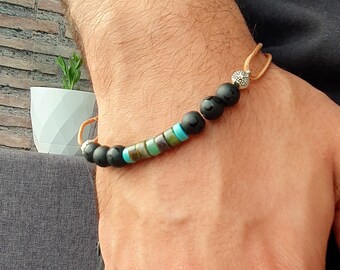 May include: A brown leather bracelet with black and turquoise beads and a silver bead accent.