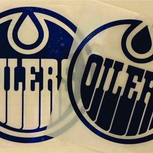 K&ouml;nnte beinhalten: Zwei runde Aufkleber mit dem Logo der Edmonton Oilers. Das Logo enth&auml;lt einen marineblauen Kreis mit wei&szlig;em Rand, eine marineblaue Tropfenform oben und das Wort "OILERS" in wei&szlig;en Blockbuchstaben.