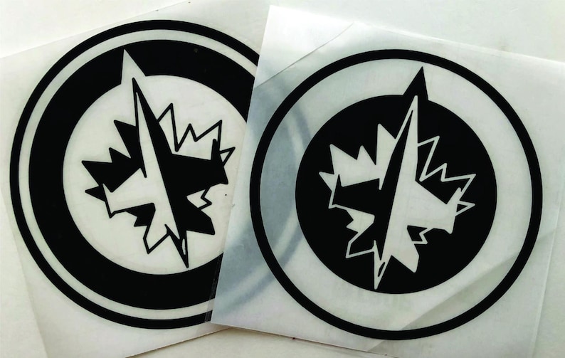 K&ouml;nnte beinhalten: Zwei kreisf&ouml;rmige schwarz-wei&szlig;e Aufkleber mit einem stilisierten Ahornblatt und einem Kompassrosen-Design. Die Aufkleber haben einen schwarzen Rand und befinden sich auf wei&szlig;em Hintergrund. Das Design ist ein Logo.