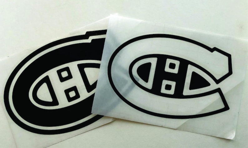 K&ouml;nnte beinhalten: Zwei schwarz-wei&szlig;e Aufkleber mit dem Logo der Eishockeymannschaft Montreal Canadiens. Das Logo ist ein stilisiertes "C" mit einem "H" darin und zwei kleinen Quadraten. Die Aufkleber befinden sich auf wei&szlig;em Hintergrund.