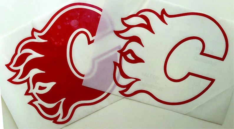 K&ouml;nnte beinhalten: Zwei rot-wei&szlig;e Vinyl-Aufkleber mit dem Logo der Calgary Flames. Das Logo ist ein stilisiertes 'C' mit einem Flammendesign. Ein Aufkleber ist vollst&auml;ndig sichtbar, der andere ist teilweise bedeckt.