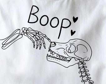 Puede incluir: Camiseta blanca con un diseño de perro esqueleto negro y el texto "Boop" con dos corazones.