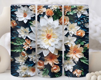 Op de afbeelding: Drie roestvrijstalen bekers met een bloemenontwerp. De bekers hebben witte, perzikkleurige en groene papieren bloemen op een donkerblauwe achtergrond.