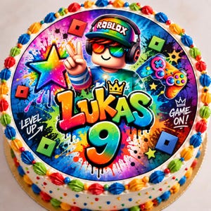 Könnte beinhalten: Ein runder Kuchen mit einem bunten essbaren Aufleger, der eine Roblox-Figur mit Regenbogenkappe und Kopfhörern, einen Controller, einen Stern sowie den Text "LUKAS 9", "LEVEL UP" und "GAME ON!" zeigt, umrandet von kleinen, bunten Frosting-Tupfen.