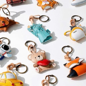 TickPick Collection Bag Charm – New York-inspirerad vegansk lädernyckelring med taxi, flygplan, djurväska och ryggsäckstillbehör