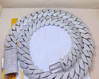 May include: A silver chain necklace with a large, intricate, diamond-like design. The chain is made of interlocking links and has a clasp closure. The necklace is displayed on a white background.