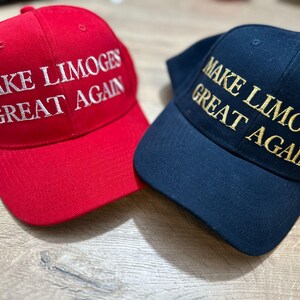 Op de afbeelding: Twee baseballpetten met de tekst "Make Limoges Great Again" erop geborduurd. De ene pet is rood met witte tekst, de andere is donkerblauw met gouden tekst.