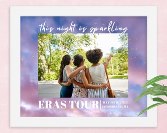 May include: White framed print featuring a photograph of three people with arms around each other. The print has a purple and blue sky background with the text "this night is sparkling" and "ERAS TOUR MAY 19TH, 2023 FOXBOROUGH, MA".