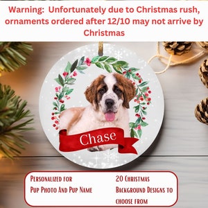May include: A round, white Christmas ornament featuring a Saint Bernard dog with a red ribbon that says "Chase". The ornament is decorated with a green wreath and red berries. Text at the top warns of potential shipping delays.