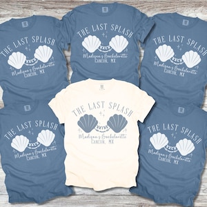 May include: A collection of short-sleeved t-shirts in blue and cream colors. Each shirt features the text "THE LAST SPLASH" above a seashell design and the text "Madison's Bachelorette CANCUN, MX".