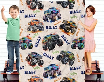 Könnte beinhalten: Eine weiche, beige Fleece-Decke mit einem sich wiederholenden Muster aus bunten Monstertrucks. Die Trucks sind mit dem Namen "Billy" verziert und haben einen aquarellartigen Effekt.