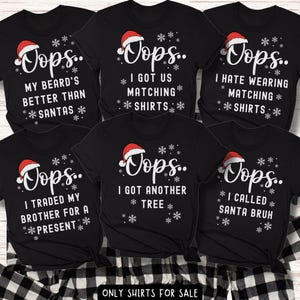 May include: Black Christmas-themed t-shirts with various white text designs and a Santa hat graphic. The text includes phrases like "Oops... I got us matching shirts" and "Oops... I called Santa Bruh". The shirts are displayed on a black and white checkered surface.