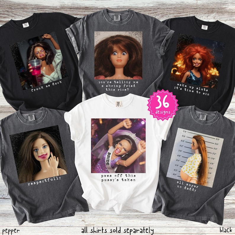 May include: A collection of black, white, and grey t-shirts with various doll graphics and text. The shirts feature phrases like "frunk as duck," "wake up sluts it's time to sin," and "paws off this pussy's taken." The image also includes the text "36 designs."