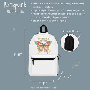 Może przedstawiać: Biały plecak z grafiką motyla i tekstem "BUTTERFLY TATTOO". Plecak ma 46 cm wysokości, 30 cm szerokości i 13 cm głębokości. Tył plecaka jest czarny.