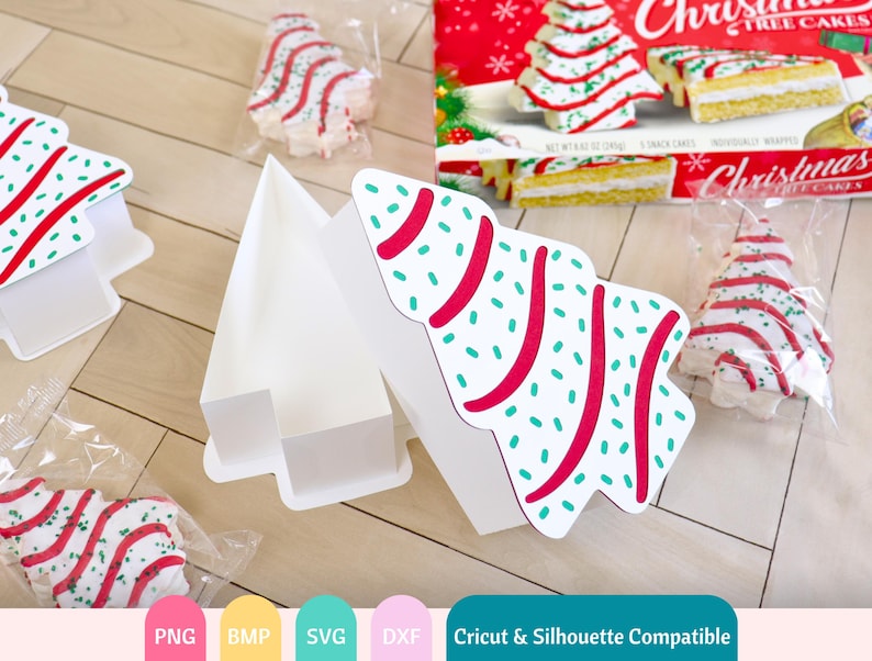 Puede incluir: Una caja de cart&oacute;n blanca en forma de &aacute;rbol de Navidad con un dise&ntilde;o de patr&oacute;n rojo y verde. La caja est&aacute; abierta y contiene tres peque&ntilde;os pasteles de &aacute;rbol de Navidad. Los pasteles est&aacute;n decorados con glaseado rojo y verde y chispas. La caja es compatible con las m&aacute;quinas de corte Cricut y Silhouette.