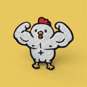 Könnte beinhalten: Gestickter Aufnäher mit einem Cartoon-Huhn, das seine Muskeln anspannt. Das weiße Huhn hat einen roten Kamm und gelbe Füße. Der Aufnäher befindet sich auf einem gelben Hintergrund.