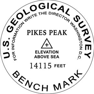 May include: Black and white circular bench mark with the text "U.S. GEOLOGICAL SURVEY" around the outside. The text "FOR INFORMATION WRITE THE DIRECTOR WASHINGTON D.C." is also included. The center of the mark reads "PIKES PEAK", "ELEVATION ABOVE SEA", and "14115 FEET".