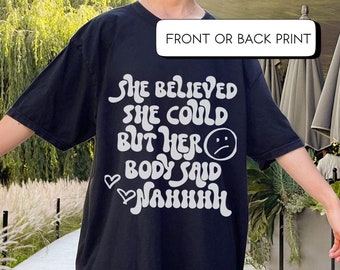Puede incluir: Camiseta negra de gran tamaño con un estampado gráfico blanco que dice "She believed she could but her body said nahhh".