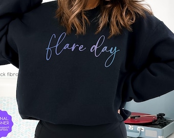 May include: A black sweatshirt with the text "flare day" in a gradient of purple and blue.