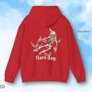 May include: Red hooded sweatshirt with a white graphic of a skeleton in flames and the text "flare day" printed on the front.