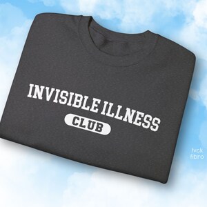 May include: A dark grey t-shirt with white text that reads "Invisible Illness Club".
