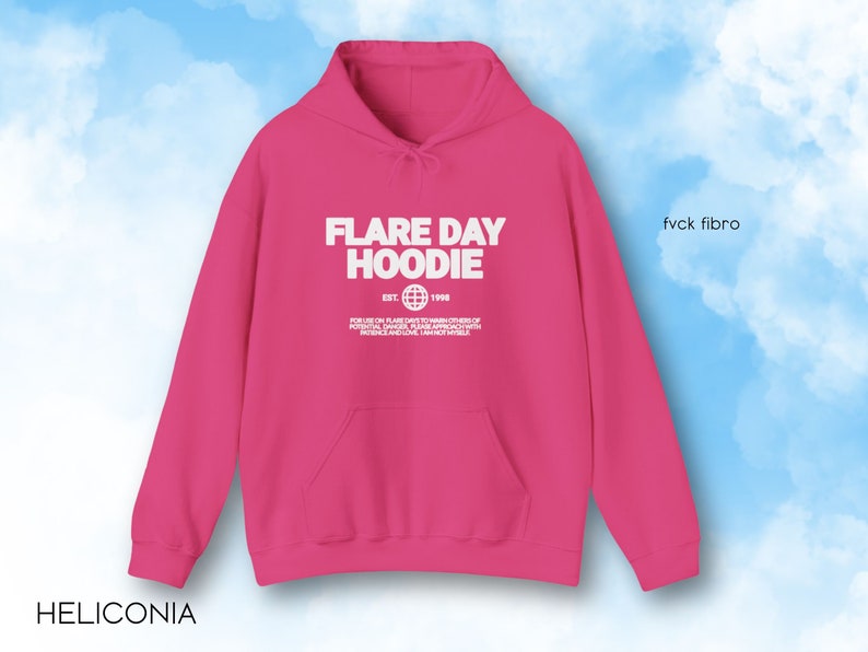 May include: A bright pink hoodie with the text "FLARE DAY HOODIE" in white. The hoodie has a front pocket and a drawstring hood. The text includes the year "EST. 1998" and a globe graphic. The text "fvck fibro" is on the right side.
