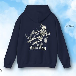 May include: Navy blue hooded sweatshirt with a white graphic of a skeleton in flames and the text "flare day".