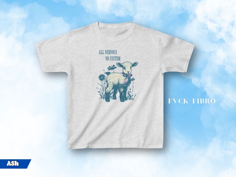 May include: Ash-colored t-shirt featuring a vintage illustration of a lamb with the text "ALL NERVOUS NO SYSTEM." The lamb is surrounded by flowers and wears a pink bow. The text "FVCK FIBRO" is also visible.