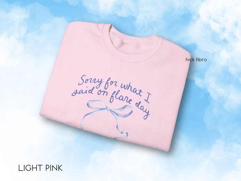 May include: Light pink sweatshirt with the text "Sorry for what I said on flare day" in blue lettering and a blue ribbon illustration.