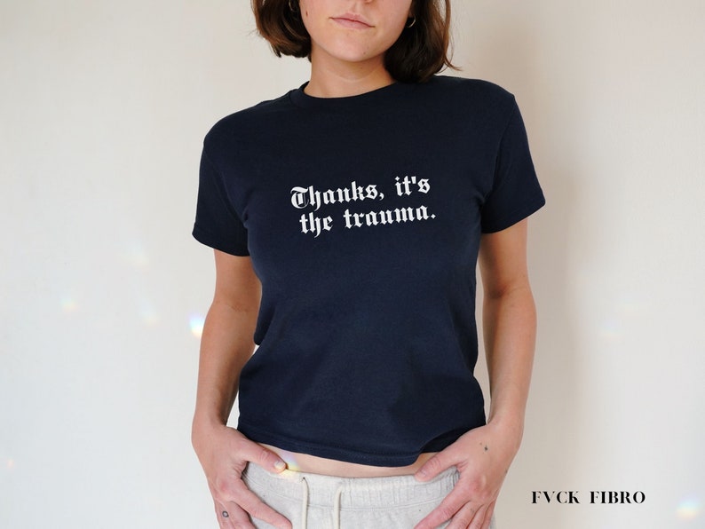 Pu&ograve; includere: Una maglietta blu navy con testo bianco che recita "Grazie, &egrave; il trauma."