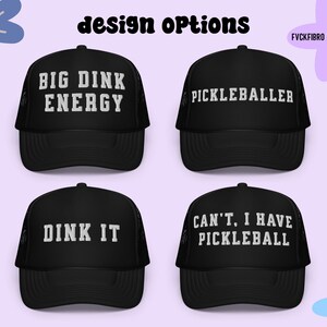 以下が含まれることがあります： 白い文字が書かれた黒いトラッカーハットが4つ。ハットには「Big Dink Energy」、「Pickleballer」、「Dink It」、「Can't, I have Pickleball」のフレーズが書かれています。