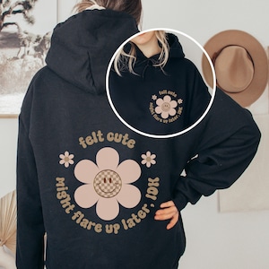 May include: Black hoodie with a pink flower graphic and the text "felt cute might flare up later, IDK".