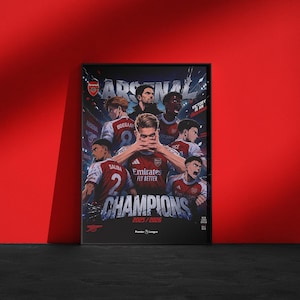 May include: A framed poster featuring Arsenal football players in red and white jerseys with the text ARSENAL, CHAMPIONS 2025/2026, VICTORY IS AN OBSESSION, and Premier League. The graphic design includes multiple athletes in a dynamic, illustrated style.