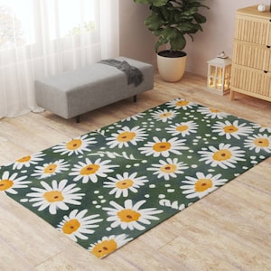 May include: A green rug with a white daisy pattern. The daisies have yellow centers and are scattered across the rug. The rug is on a wooden floor.