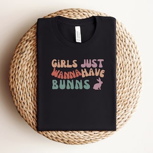 May include: Black t-shirt with a rainbow-colored graphic that says "Girls Just Wanna Have Bunns" with a pink bunny rabbit illustration.