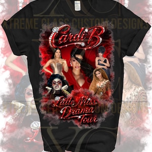 May include: Black t-shirt featuring a graphic design with the text "Cardi B" in red, embellished with diamonds. The design includes multiple images of Cardi B and the text "Little Miss Drama Tour".
