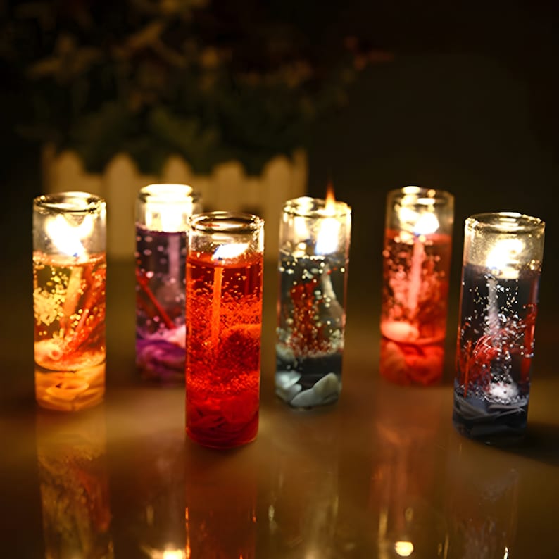 May include: Six glass candle holders with clear gel candles. The candles are in various colors, including red, blue, purple, and yellow. The candles are lit and casting a warm glow.