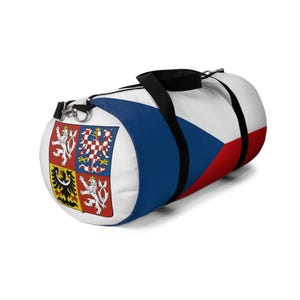 May include: A white, blue, and red duffel bag with the Czech Republic flag and coat of arms printed on it. The bag has black straps and a zipper closure.