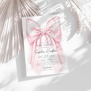 Op de afbeelding: Een babyborrel uitnodiging met een grote, aquarel roze strik. De uitnodiging bevat de tekst "Join us for a Baby Shower in Honor of Sophia Hudson" en evenement details. Het ontwerp staat op een witte achtergrond met zachte schaduwen.