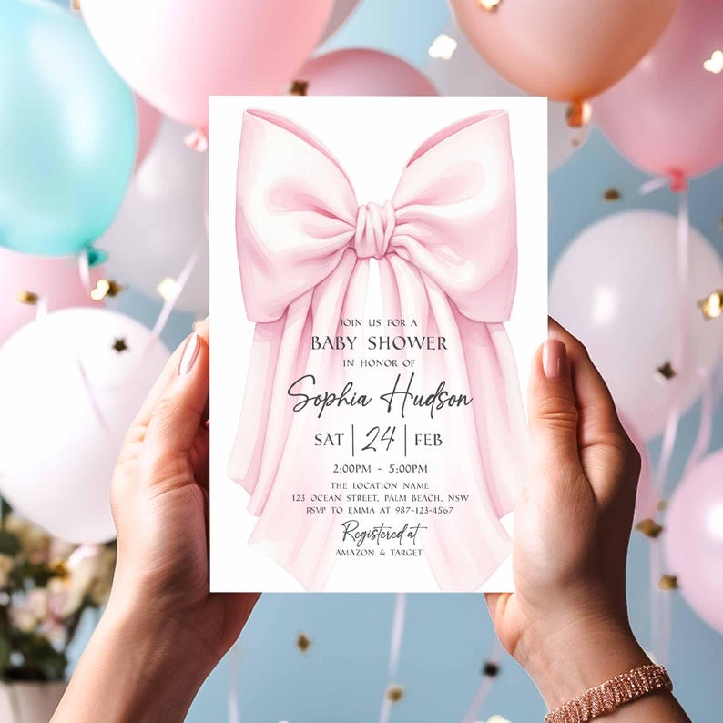 Op de afbeelding: Een uitnodiging voor een babyshower met een roze strik illustratie. De uitnodigingstekst luidt "Join us for a Baby Shower in Honor of Sophia Hudson" met de datum, tijd en locatie. De uitnodiging wordt vastgehouden tegen een achtergrond van roze en blauwe ballonnen.