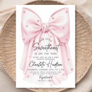 May include: A baby shower invitation featuring a large pink bow adorned with small pink hearts. The text reads "Our Little Sweetheart Is On The Way!" and includes details for Charlotte Hudson's baby shower, including date, time, and location.