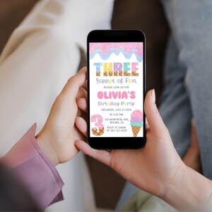 May include: A smartphone displays a colorful birthday party invitation. The invitation reads "THREE Scoops of Fun" and "OLIVIA'S Birthday Party". The design includes ice cream cones and sprinkles in pastel colors. The date is Saturday, July 27, 2024.