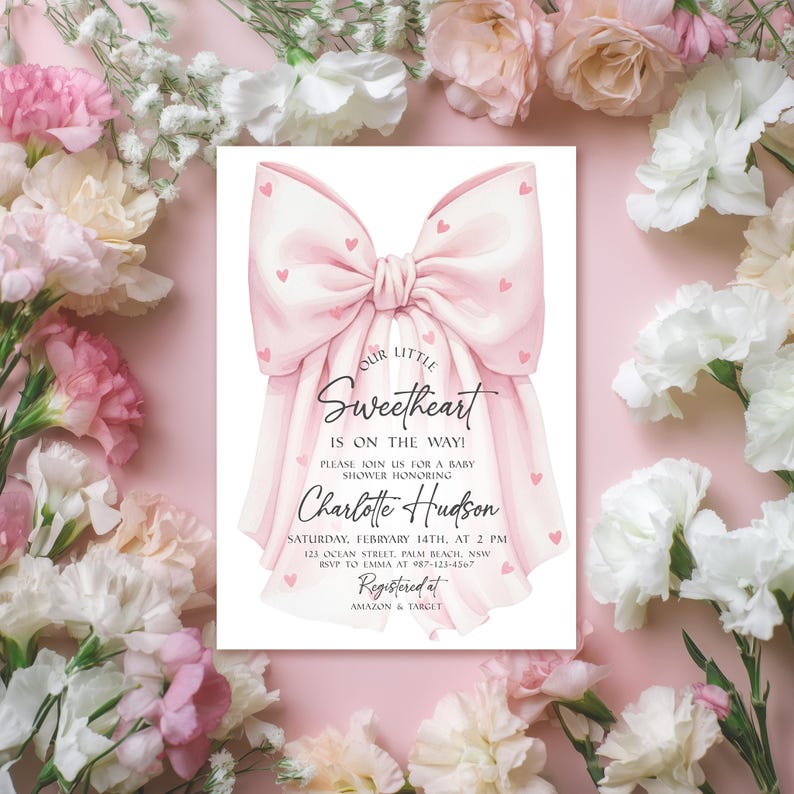 May include: A baby shower invitation featuring a large pink bow with small red hearts. The invitation reads "Our Little Sweetheart is on the way!" and includes details for the event, including the name Charlotte Hudson.