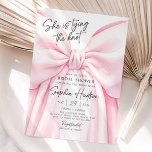 K&ouml;nnte beinhalten: Eine Einladung zur Brautparty mit einem gro&szlig;en rosa Schleifendesign und dem Text "She is tying the knot". Die Einladung enth&auml;lt Details f&uuml;r Sophia Hudsons Brautparty, einschlie&szlig;lich Datum, Uhrzeit und Ort. Registriert bei Amazon & Target.